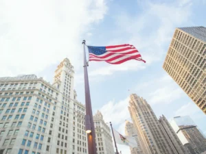 United States flag flying among city skyscrapers