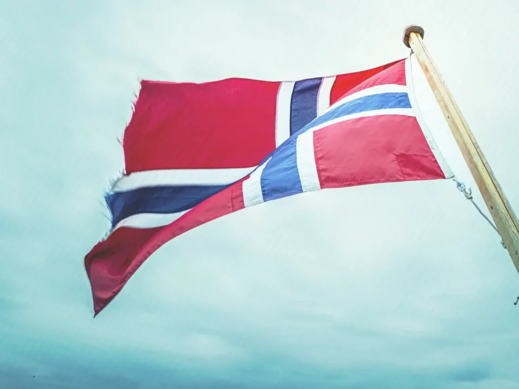 Norwegian flag flying against a pale sky