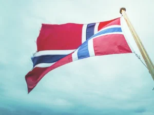 Norwegian flag flying against a pale sky